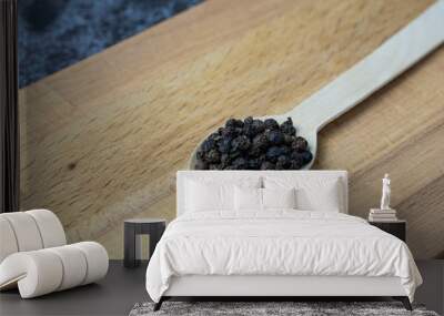 Black pepper on wooden spoon. Wall mural