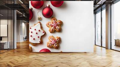 Artful display of ginger cookies and glossy red ornaments on white surface. Wall mural