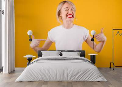 Silly smiling funny woman in white t-shirt where you can place ypur logo text or image. Yellow background Wall mural