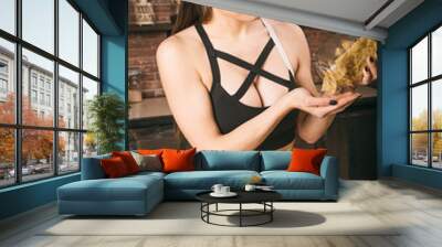 Sporty fit girl with the expressive muscles of the stomach abs cooking pasta in the kitchen. Healthy sports nutrition long carbohydrates Wall mural