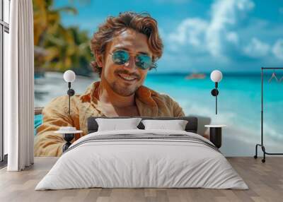 A handsome and satisfied man on the coastline, using a smartphone in a tropical paradise. Wall mural