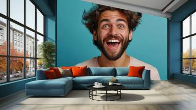 A handsome man exudes excitement and joy in his portrait, showcasing trendy fashion with a stylish beard Wall mural