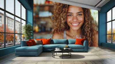 A happy and attractive Hispanic woman enjoys a nutritious organic juice, radiating health and happiness. Wall mural