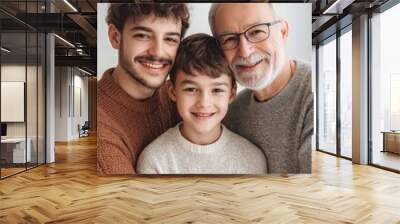 A man, a boy and a little boy are hugging each other. The man is wearing glasses and the boy is wearing a white shirt. Scene is happy and loving Wall mural