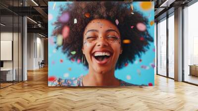 A woman with a big smile on her face is surrounded by colorful confetti. Concept of joy and celebration Wall mural