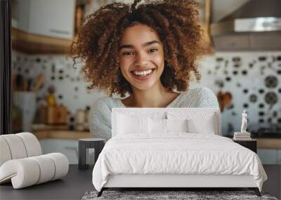 A woman with curly hair is smiling and holding a bowl of cereal. The kitchen is well-equipped with various utensils and appliances, including a refrigerator, oven, and microwave Wall mural