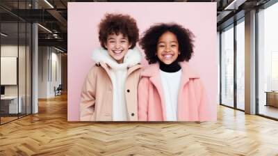 Adorable happy children, girl and boy in warm clothes on a pink background. Wall mural