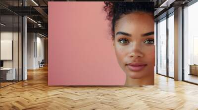 Beauty portrait of African American woman with curly hair on blush pink background with copy space. Skin care and natural cosmetics concept. Wall mural