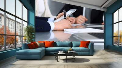 Business people discussing contract working together at meeting at the glass desk in modern office. Unknown businessman and woman with colleagues or lawyers at negotiation. Teamwork and partnership Wall mural