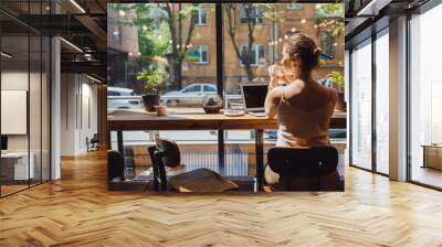 Caucasian romantic woman blogger relaxing drinking tea while sitting near the window in modern loft cafe bar,female freelancer thinking about new ideas during work on laptop computer. Copy space Wall mural