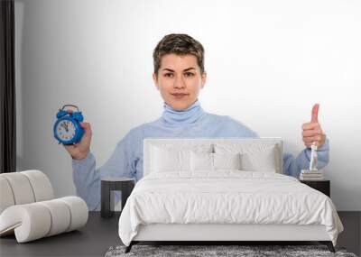 Confident Woman With Blue Alarm Clock Showing Positivity in Casual Sweater Wall mural