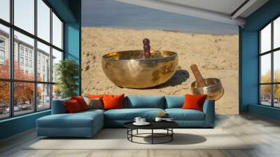 Two Tibetan bowls on a sandy beach Wall mural