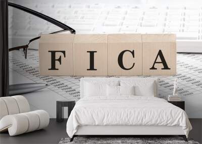 FICA written on wooden cube with keyboard , calculator, chart,glasses.Business concept Wall mural