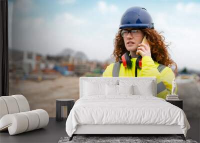 Focused Construction Worker on Site Engaged in Important Phone Call During Daylight Hours Wall mural