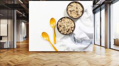 Full grain muesli with dried fruits in two clay bowl on white kitchen table. Healthy and tasty breakfast idea. Copy space for your text. Wall mural