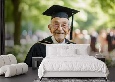 Happy senior male graduate celebrating his academic achievements wearing cap and gown outdoors. Wall mural