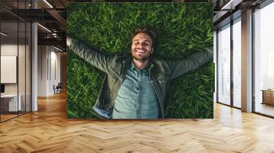 Happy young man enjoying summer in the park, surrounded by nature, emitting a carefree and positive atmosphere. Wall mural