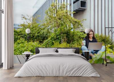 hardworking inventive woman developing her engineering project, having coffee to go outdoor in moder Wall mural