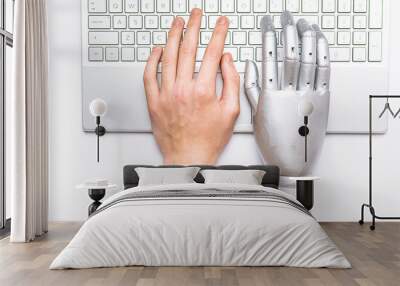 Human and robotic hands on the keyboard. Concept of collaboration between people and Artificial Intellegence. Wall mural