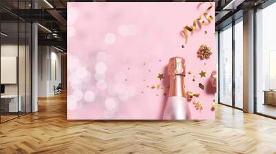 Long wide Christmas and New Year’s banner with rose Champagne bottles, golden decorations and bokeh lights on pink pastel background. Festive party banner template with copy space for your text. Wall mural