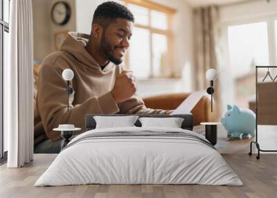 Man Reviewing Financial Documents With Piggy Bank on Table Wall mural