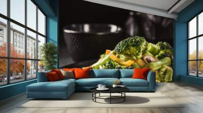 Hot stir fried vegetables on black plate. Healthy asian food concept with copy space. Toned Wall mural