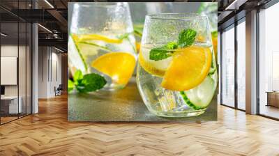 Summer healthy lemonade, cocktails of citrus infused water or mojitos, with lime lemon orange, ice and mint, diet detox beverages, in glasses on gray background. Banner Wall mural