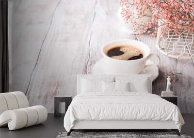 White cup of coffee with pink flowers on old white wooden background with copy space. Wall mural