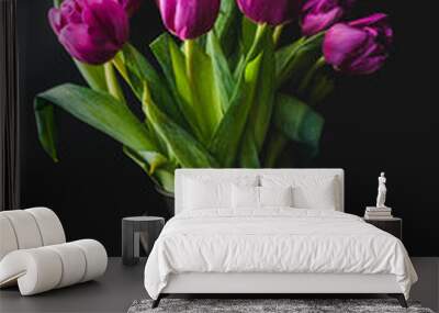 Lilac purple tulip flowers on table. Spring bouquet flowers in vintage vase. Floral concept. Floral background. Dark black background. Wall mural