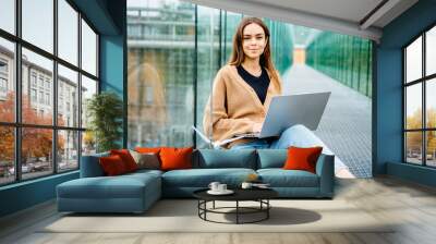 Portrait of smart young positive woman university student working study with ecology project outdoor at modern building terrace with green garden. Education study brainstorm success people concept. Wall mural