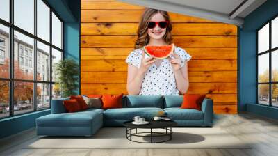 Portrait of teenage girl eating watermellon on wooden background. Young female enjoy life on summer. Outdoor travel vacation healthy lifestyle vegan food picnic children with snacks. Wall mural