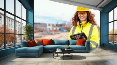 redhead female site engineer surveyor working with theodolite total station EDM equipment on a building construction site outdoors Wall mural