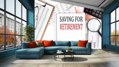 SAVING FOR RETIREMENT text on notebook with clipboard and calculator on a chart background Wall mural