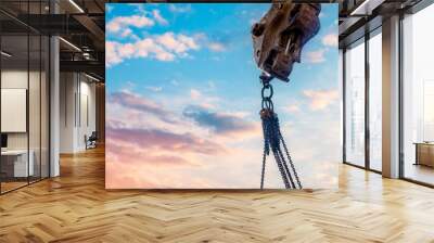 Steel chain attached to the excavator's arm. Lifting gear against blue sky with space for text as an abstract industrial background Wall mural