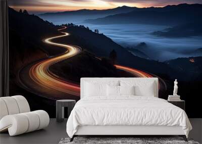 Stunning panoramic view of a winding illuminated mountain road at dusk, surrounded by natural beauty and greenery. Wall mural