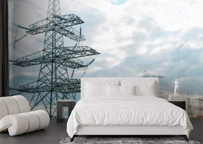 Tall Steel Transmission Towers Against Cloudy Sky Wall mural