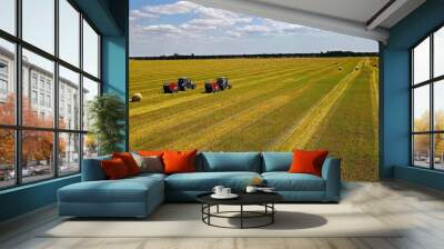 Tractors Harvesting Hay in Agricultural Field. A wide aerial view of two tractors harvesting hay in an expansive agricultural field. Wall mural