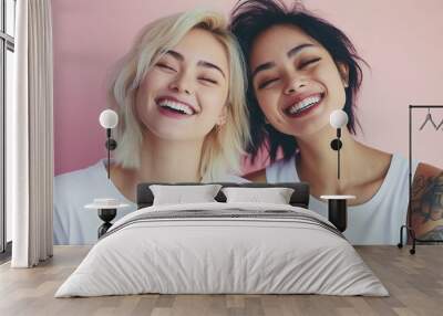 Two women with tattoos on their arms are smiling and posing for a picture. Scene is happy and carefree Wall mural