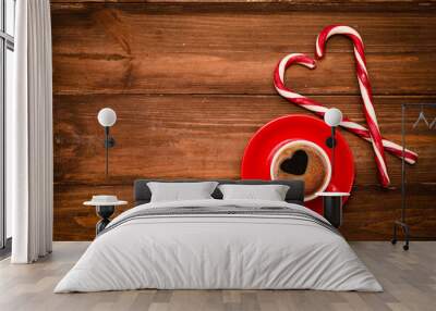 A red cup coffee and candy cane sticks on a wooden texture. Christmas drink theme. Wall mural