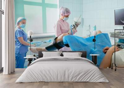 Woman gynecologist and female assistant with hysteroscopy equipment carry out operation in ginecology medical center. Wall mural