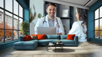 
A happy and nice male doctor in a hospital room, showing test results on a computer screen and talking with a young woman patient. Wall mural