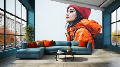 woman outdoor fashion style winter urban casual trendy portrait young female red beanie orange jacket backpack cold weather cityscape looking up urban fashion  Wall mural