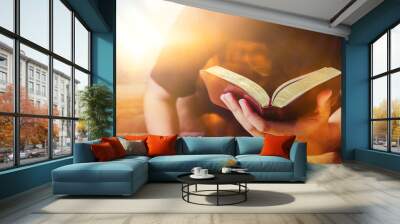 Close up of a man hand holding the holy bible on wooden table against the sunlight with bokeh, Christian bible study or devotional concept copy space for your text Wall mural