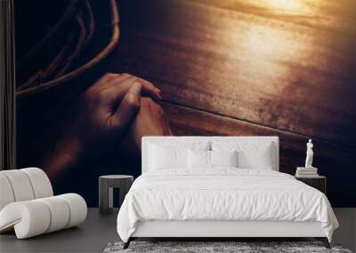 close up of woman hands prays near crown of throne on wooden table with sunlight from window, Christian background, Easter concept with copy space Wall mural