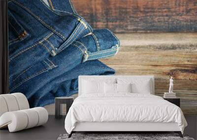 Blue jeans on a wooden surface, close up Wall mural