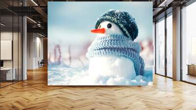 Little cute snowman in a knitted hat and scarf on snow on a sunny winter day. Christmas card Wall mural