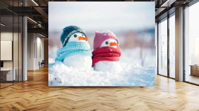 Two little snowmen the girl and the boy in knitted caps and scarfs on snow in the winter. Festive background with a lovely snowman. Christmas card, copy space Wall mural