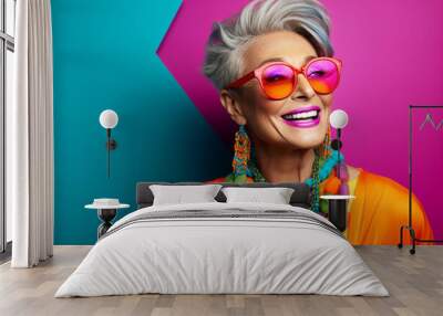 Matured middle aged stylish modern woman wearing bright colored cloths in copy space minimal background, smiling short hair happy woman wearing luxury stone and perl jewelries and a pair of sunglasses Wall mural