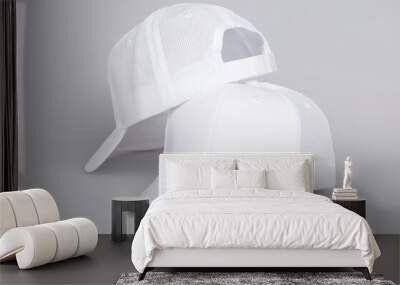 Two white baseball caps isolated on a gray background front and back view, white trucker hat mock up and template Wall mural