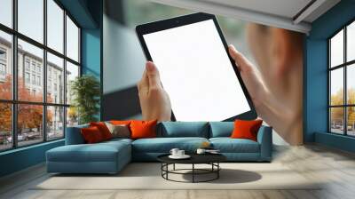 A person holds a tablet with a blank white screen, providing a clean design for presenting information or showcasing a technology concept. Wall mural